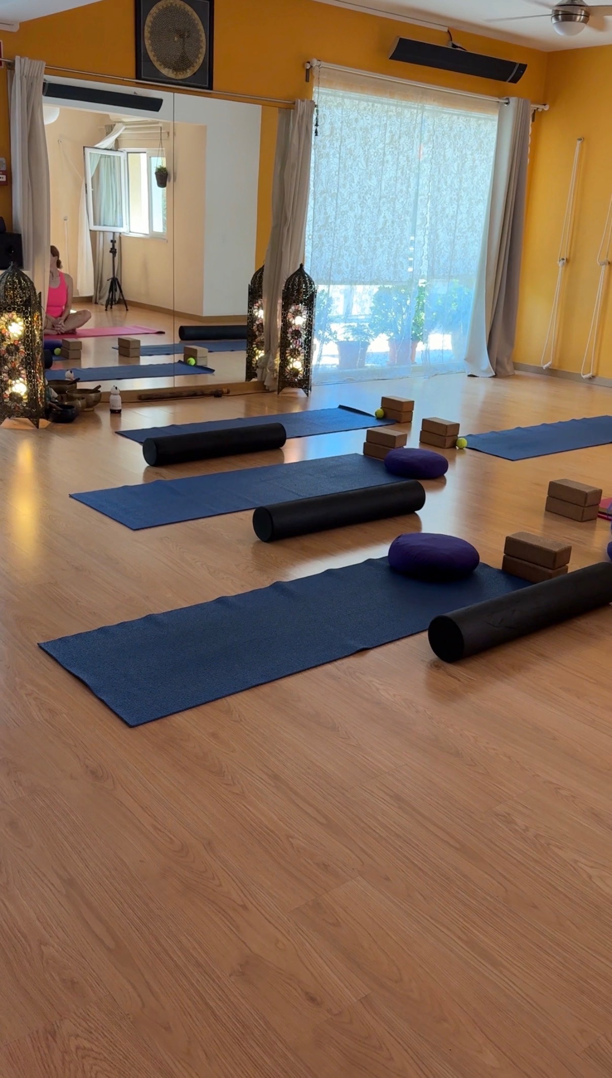 Exercise mats, foam rollers, blocks, and cushions in the sunlit studio